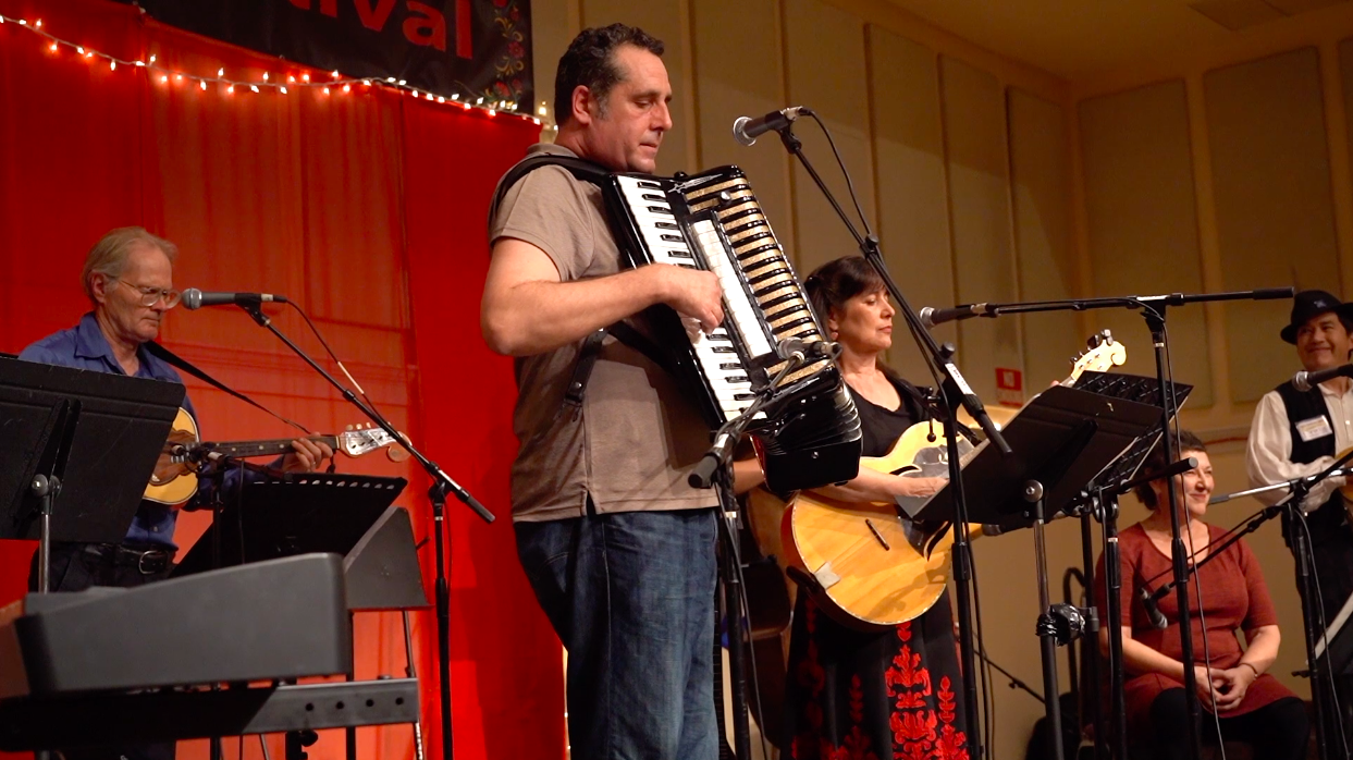 Close-up of a band performing with guitars, vocals, and a garmon (Russian accordion)